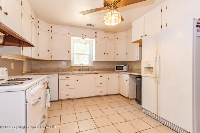 a kitchen with cabinets appliances and a window
