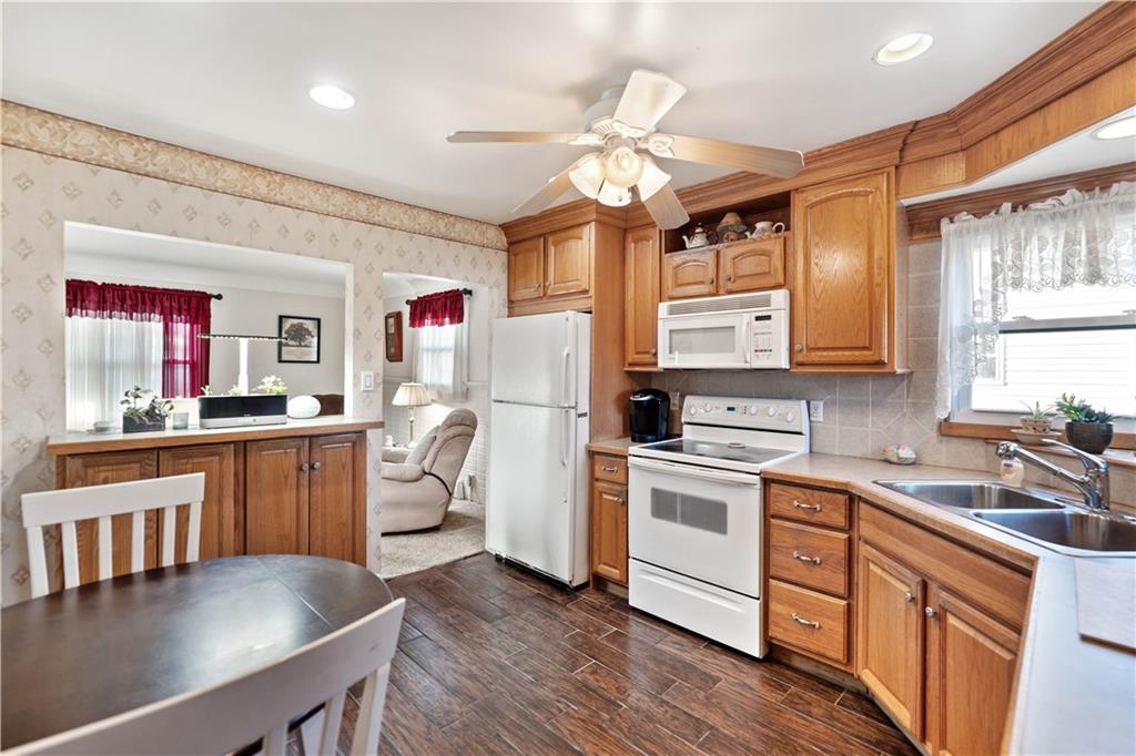 1007 Thermo Village Road New Stanton, PA 15672 - Photo 12 of 21 a kitchen with cabinets a sink dishwasher and a stove with wooden floor