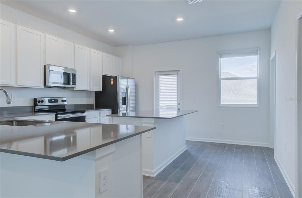 15627 Water Spring Boulevard Winter Garden, FL 34787 - Photo 14 of 45 a kitchen with stainless steel appliances granite countertop a stove a sink and a microwave