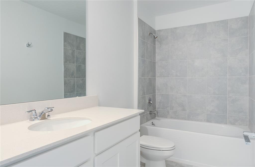 15627 Water Spring Boulevard Winter Garden, FL 34787 - Photo 24 of 45 a bathroom with a granite countertop sink a toilet and shower