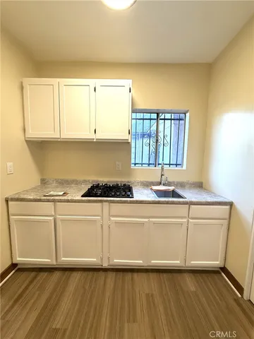 a view of a kitchen with wooden floor and a sink