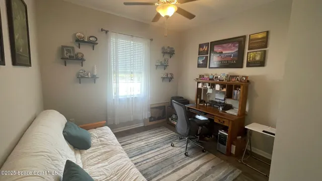 a bedroom with a bed and a chandelier fan