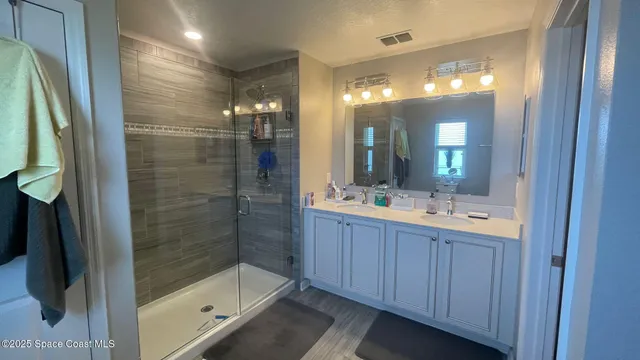 a bathroom with double vanity and a shower