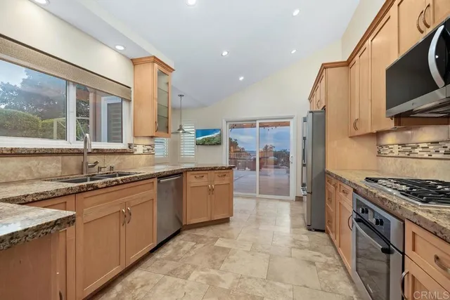 a kitchen with stainless steel appliances granite countertop a stove sink and cabinets
