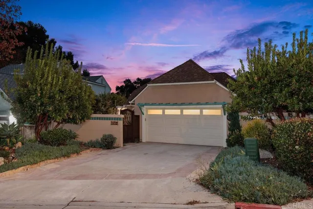a front view of a house with a yard and tree s