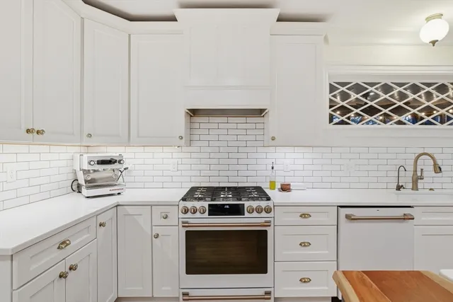 a kitchen with granite countertop a sink a stove a microwave and cabinets