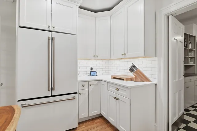 a kitchen with white cabinets and white appliances