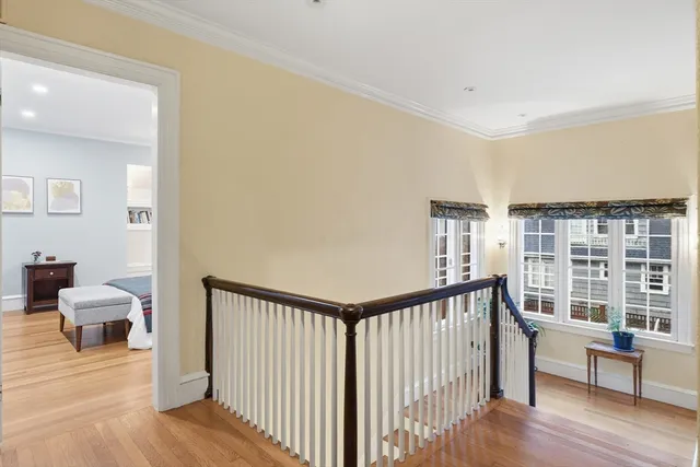 a view of a hallway with furniture and wooden floor