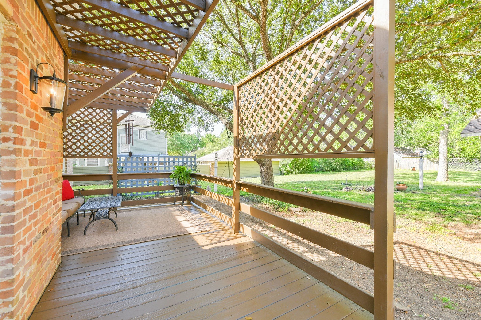 802 South Day Street Brenham, TX 77833 - Photo 16 of 50 a porch with a bench and wooden floor next to a yard