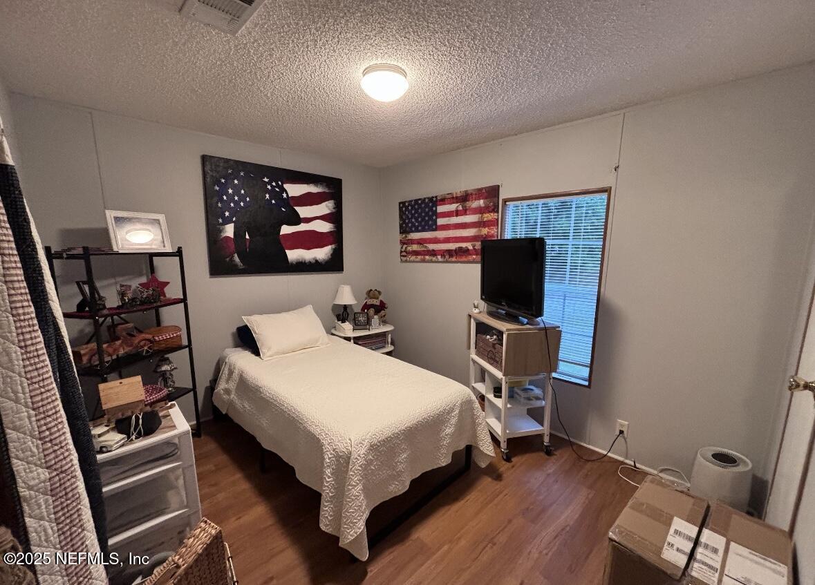 86266 Weldon Road Yulee, FL 32097 - Photo 8 of 10 a bedroom with a bed and a flat screen tv
