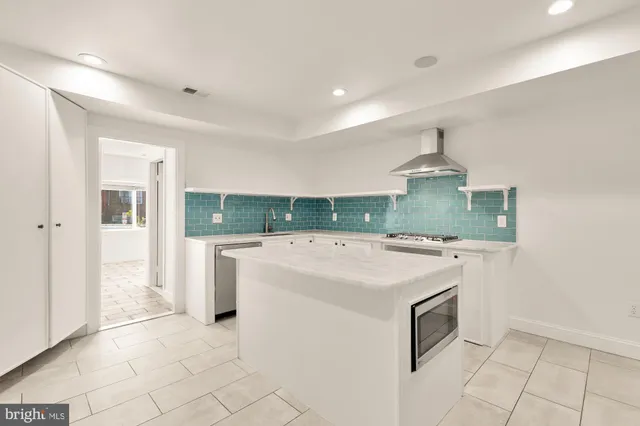 a kitchen with stainless steel appliances granite countertop a sink and a refrigerator