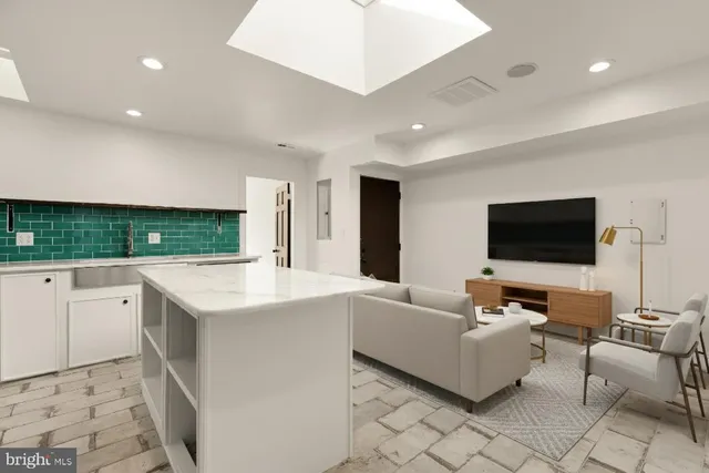 a living room with kitchen furniture and a flat screen tv