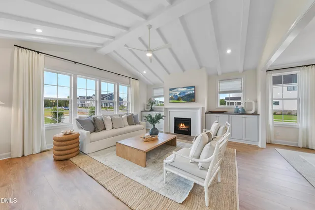 a living room with furniture a fireplace and a large window