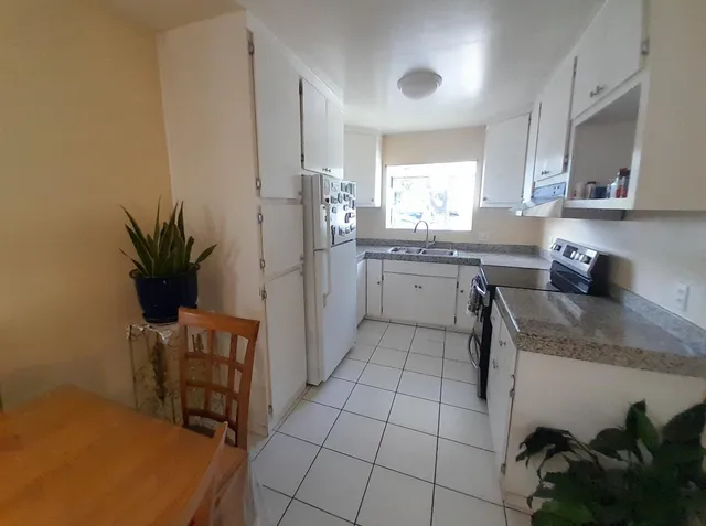 a kitchen with stainless steel appliances granite countertop a sink and a refrigerator