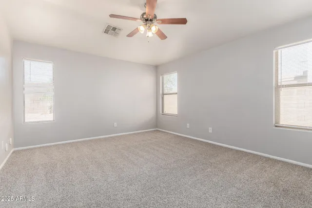 an empty room with a ceiling fan and a window