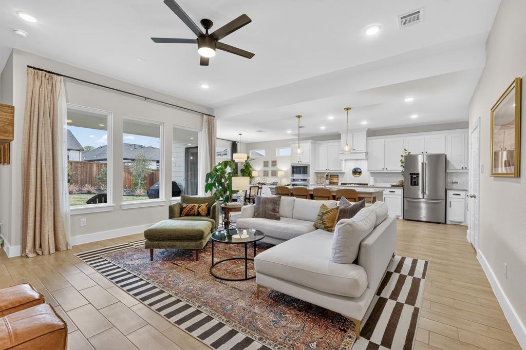 a living room with furniture kitchen view and a large window