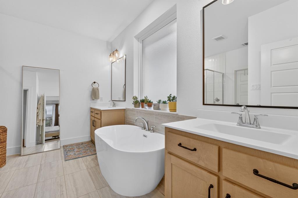 7117 Mantle Ridge Drive Fort Worth, TX 76179 - Photo 20 of 38 a bathroom with a tub sink and mirror