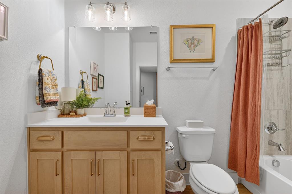 7117 Mantle Ridge Drive Fort Worth, TX 76179 - Photo 26 of 38 a bathroom with a sink a toilet a mirror and shower curtain