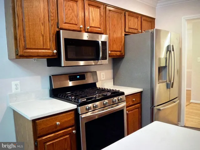 a kitchen with stainless steel appliances granite countertop a refrigerator stove and microwave