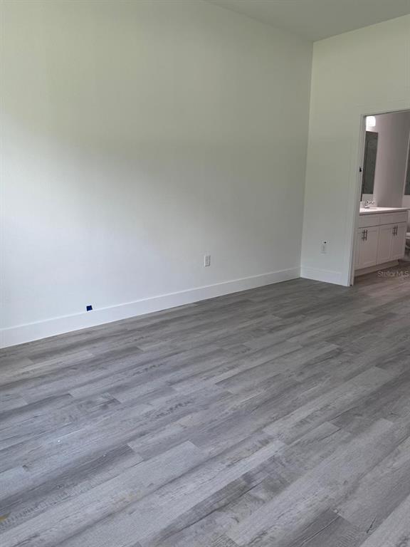 9187 North Travis Drive, Unit 9189 Citrus Springs, FL 34434 - Photo 14 of 21 an empty room with wooden floor and windows