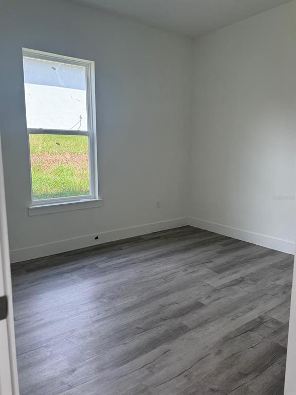 9187 North Travis Drive, Unit 9189 Citrus Springs, FL 34434 - Photo 8 of 21 an empty room with wooden floor and a window