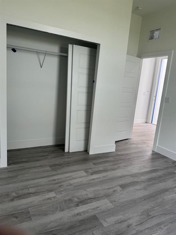 9187 North Travis Drive, Unit 9189 Citrus Springs, FL 34434 - Photo 9 of 21 a view of an empty room with wooden floor and a window