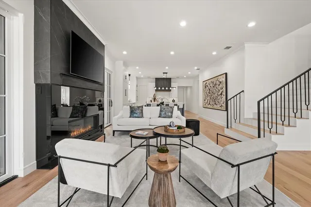 a living room with furniture a flat screen tv and kitchen view