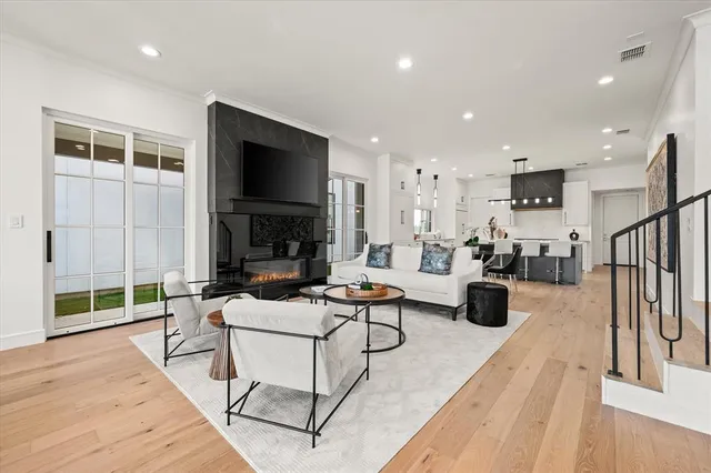 a living room with furniture a flat screen tv and a floor to ceiling window