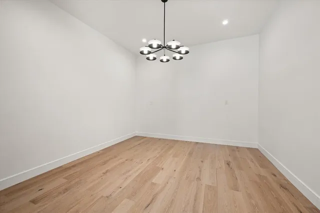a view of a room with wooden floor chandelier fan and a window