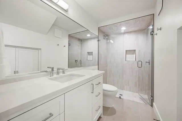 a bathroom with a sink a toilet a shower and a mirror