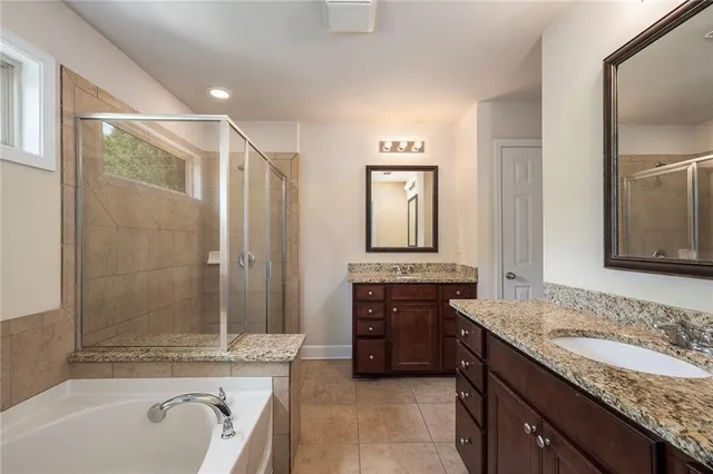 a bathroom with a granite countertop tub sink and mirror