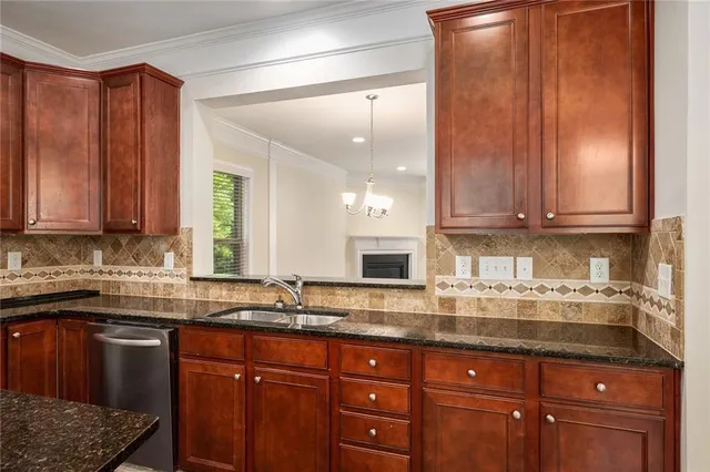 a kitchen with stainless steel appliances granite countertop a sink a stove and cabinets