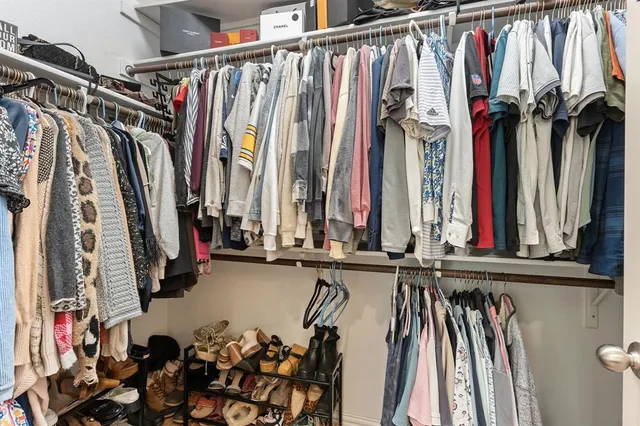 a view of walk in closet with clothes