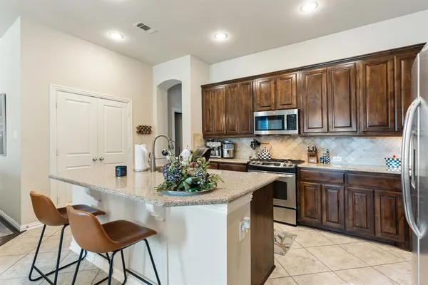 a kitchen with stainless steel appliances kitchen island granite countertop a stove sink and cabinets