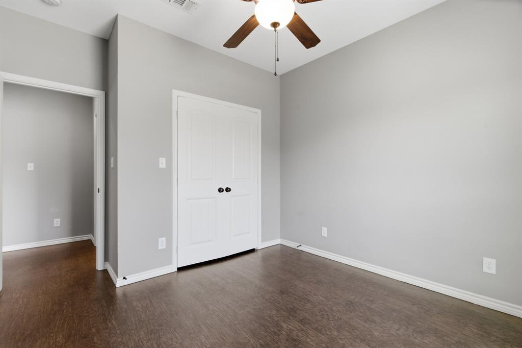 711 Hadley Lane Valley View, TX 76272 - Photo 14 of 40 Unfurnished bedroom featuring a closet, dark wood-style flooring, and ceiling fan