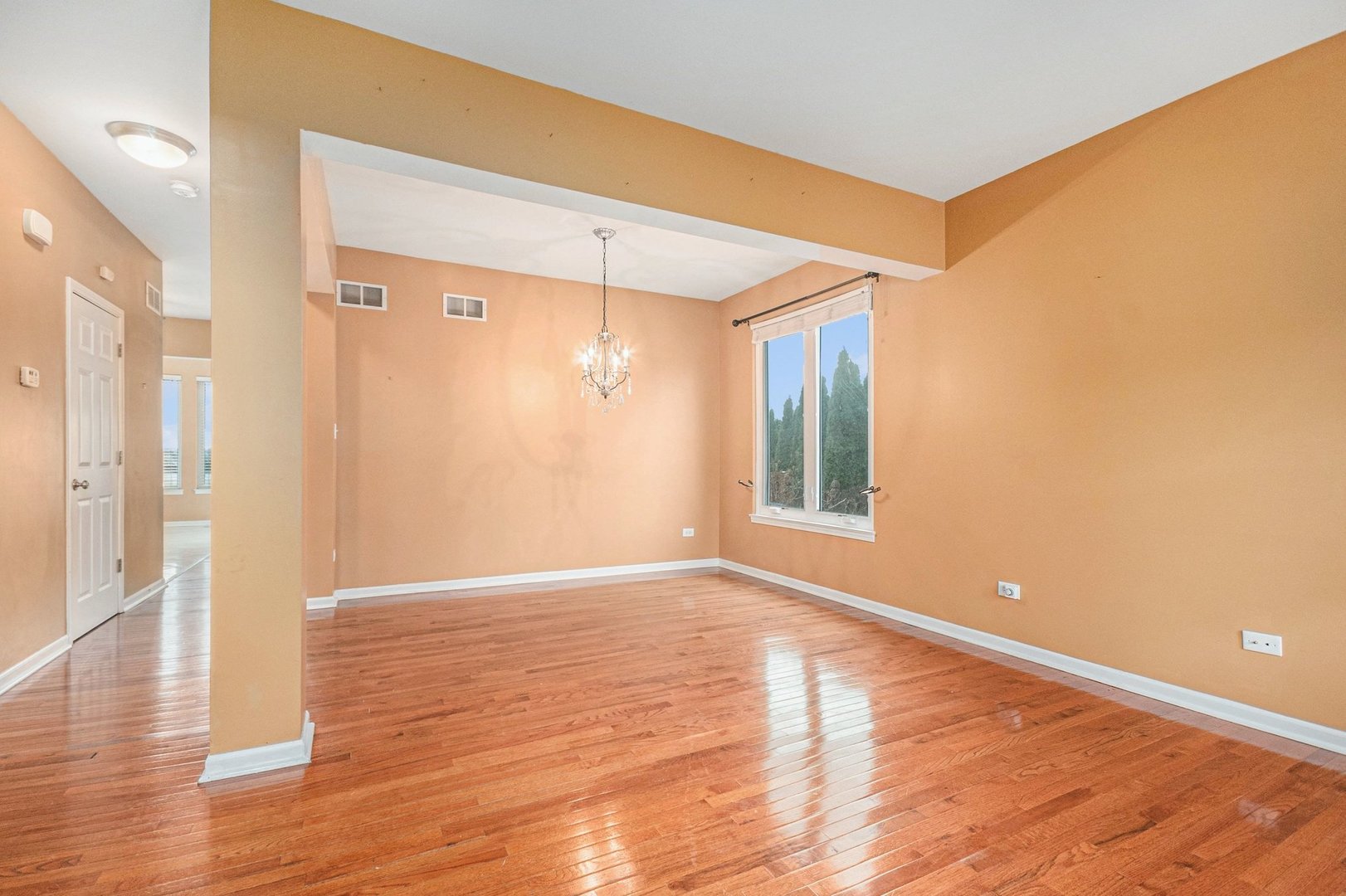 1616 Stanton Lane Plainfield, IL 60586 - Photo 5 of 40 a view of an empty room with wooden floor and a window