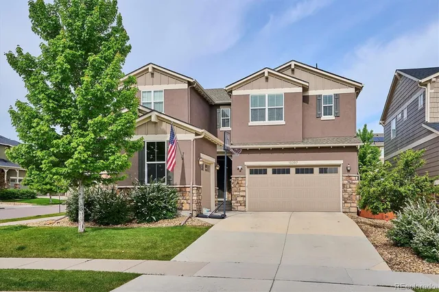 a view of a house with a yard and large tree