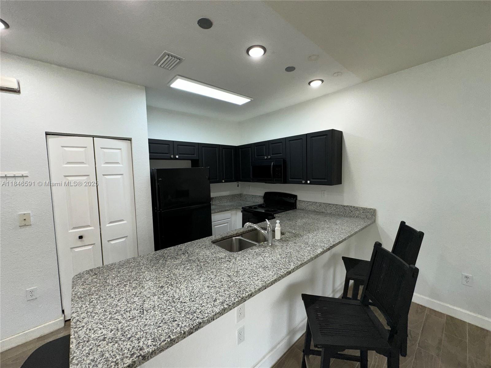 4908 Southwest 141st Avenue, Unit 3 Miramar, FL 33027 - Photo 12 of 29 a kitchen with a table and chairs in it