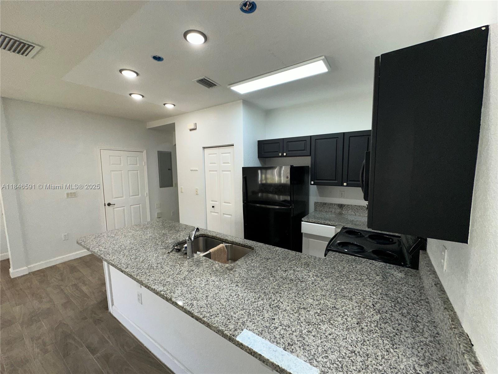 4908 Southwest 141st Avenue, Unit 3 Miramar, FL 33027 - Photo 8 of 29 a kitchen with granite countertop a refrigerator and a sink