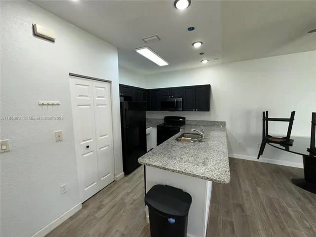 a kitchen with stainless steel appliances kitchen island granite countertop a refrigerator and a stove top oven