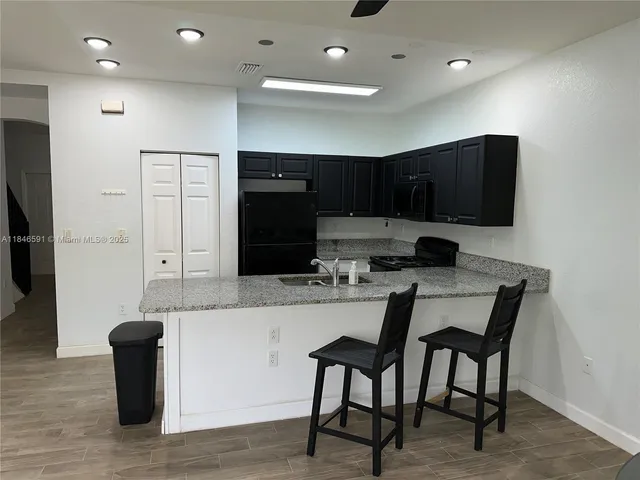 a kitchen with counter top space a sink and appliances