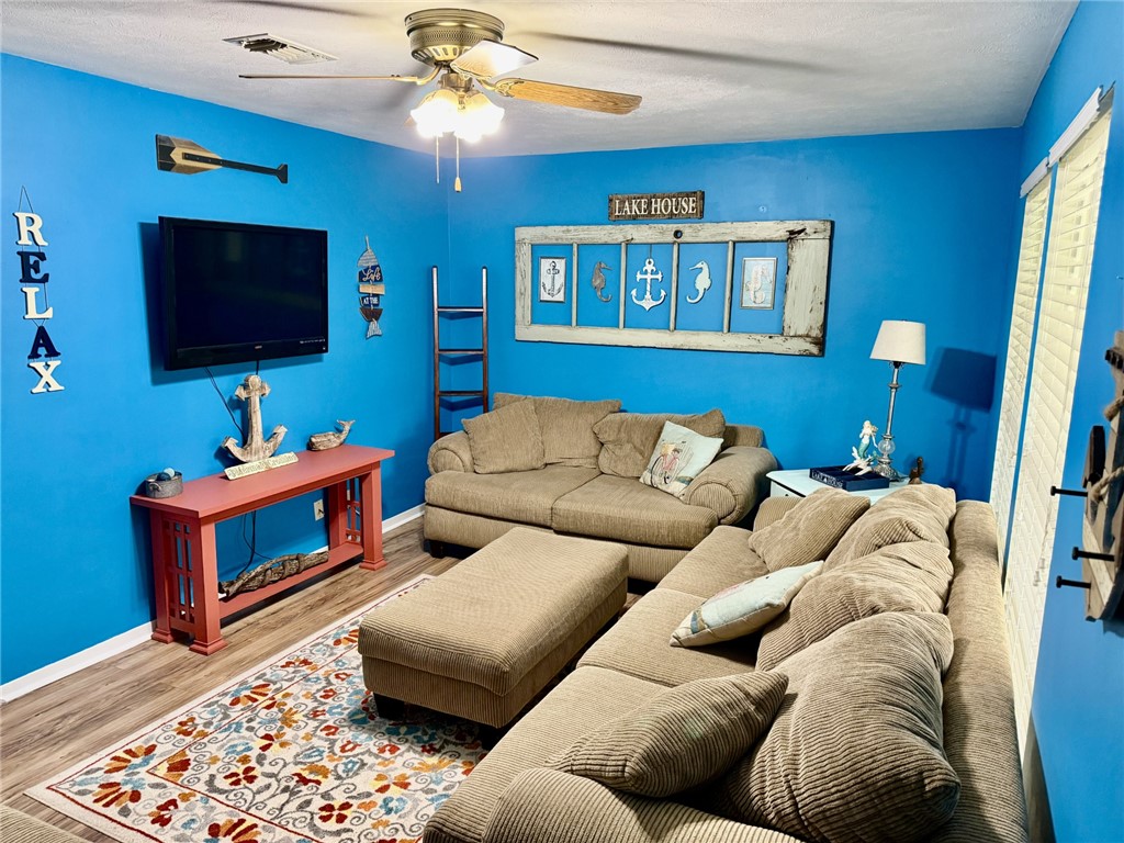 712 Tanglewood Somerville, TX 77879 - Photo 14 of 42 Living area featuring wood finished floors and ceiling fan