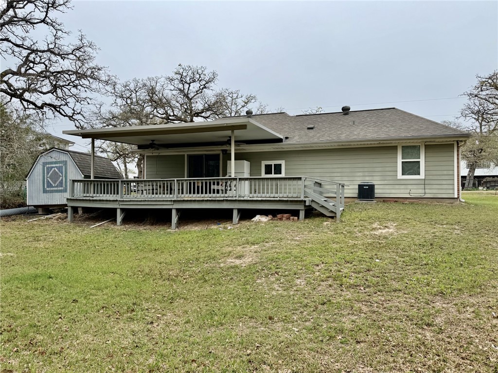 712 Tanglewood Somerville, TX 77879 - Photo 21 of 42 Back of house with a wooden deck, a lawn, a storage unit.