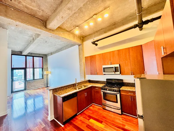 a kitchen with granite countertop a stove and a refrigerator