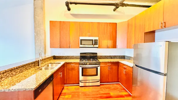 a kitchen with a stove a refrigerator and a microwave
