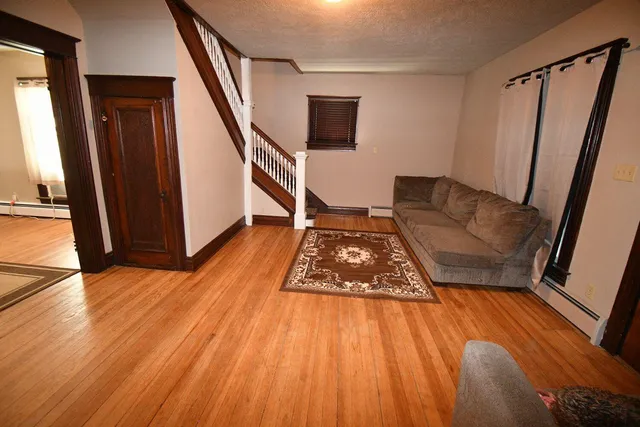 a living room with wooden floor and a rug