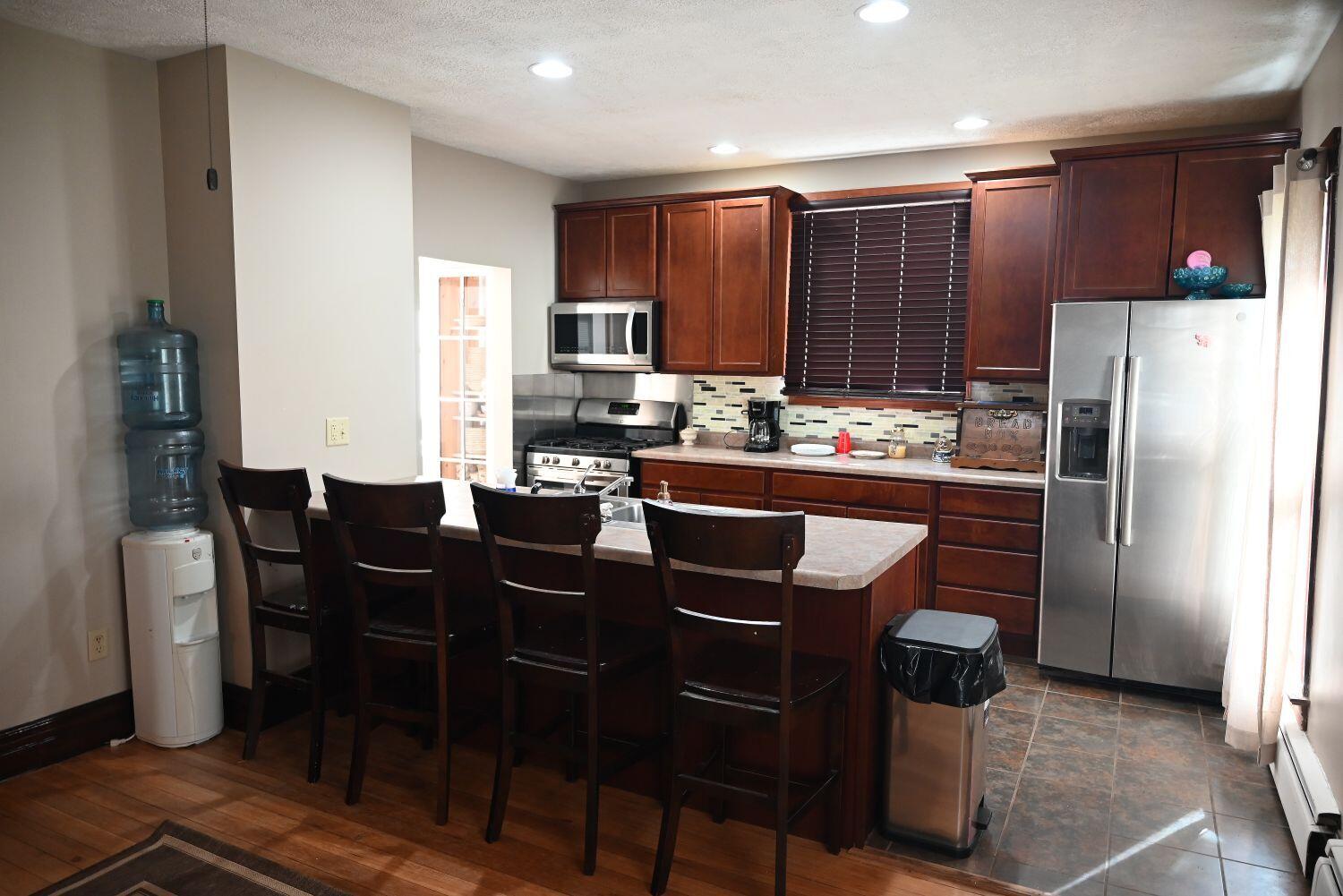 513 North College Avenue Rensselaer, IN 47978 - Photo 8 of 29 a kitchen with a table chairs refrigerator and microwave