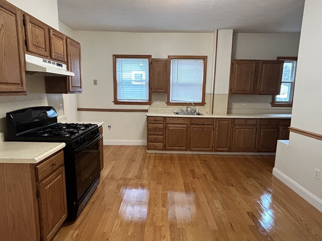 125 Spring Street, Unit 1 Medford, MA 02155 - Photo 1 of 12 a kitchen with wooden floors and appliances