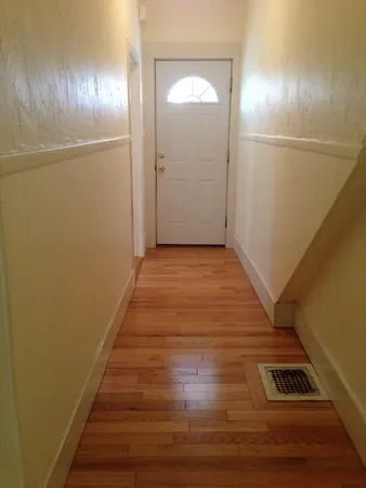 a view of a hallway with wooden floor