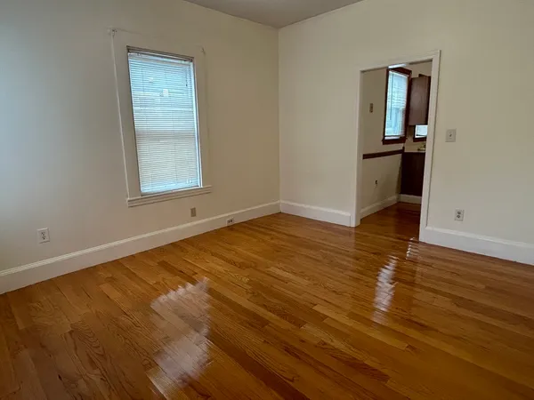 an empty room with wooden floor and closet